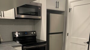 A modern kitchen with a stainless steel refrigerator, a microwave, and a stove.