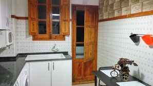 Une cuisine avec des meubles en bois, un évier blanc et un plan de travail.