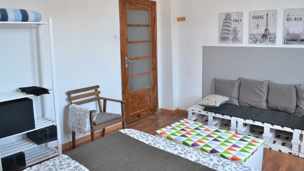 Une petite pièce agréable et chaleureuse, avec une porte en bois, un canapé, un fauteuil et une petite table.