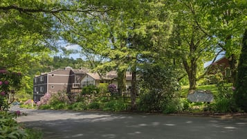 Une rue résidentielle bordée de maisons, avec une enseigne indiquant « RÉSIDENCE ROYALE OAK », et une végétation luxuriante.