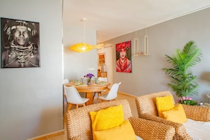 A dining area with a round table, white chairs, and a hanging light fixture. - Apartment 'Playa Arenal Grupo Terra De Mar' with Sea View, Wi-Fi and Air Conditioning (Calpe)