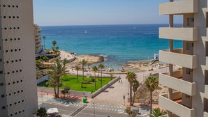 A coastal hotel with a view of the sea, a beach area with palm trees, and a parking lot. - Apartment 'Playa Salinas Grupo Terra De Mar' with Sea View, Wi-Fi and Air Conditioning (Calpe)