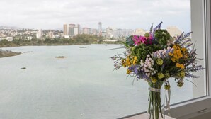 A cityscape view through a window with a vase of flowers on a wooden table. - Apartment 'Playa Salinas Grupo Terra De Mar' with Sea View, Wi-Fi and Air Conditioning (Calpe)