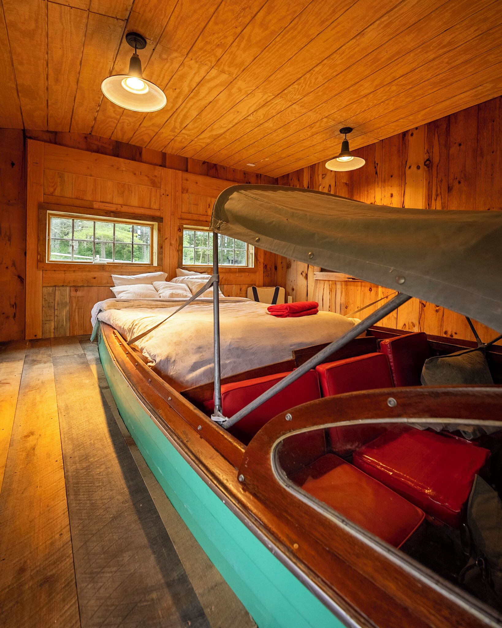 Une chambre de style cabane avec un intérieur en bois, un lit superposé et un lit en forme de bateau.