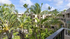 Un hôtel doté de nombreux balcons, d’une végétation tropicale luxuriante et offrant une vue sur un ciel dégagé.