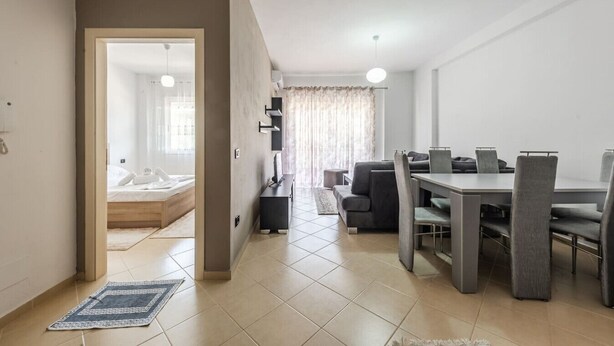 Ein modernes Hotelzimmer mit Essbereich, einer Couch und einem Bett.
