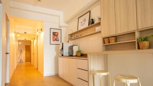 A modern kitchen with wooden cabinets, a countertop, and two stools. - Minima 8  (George Town)