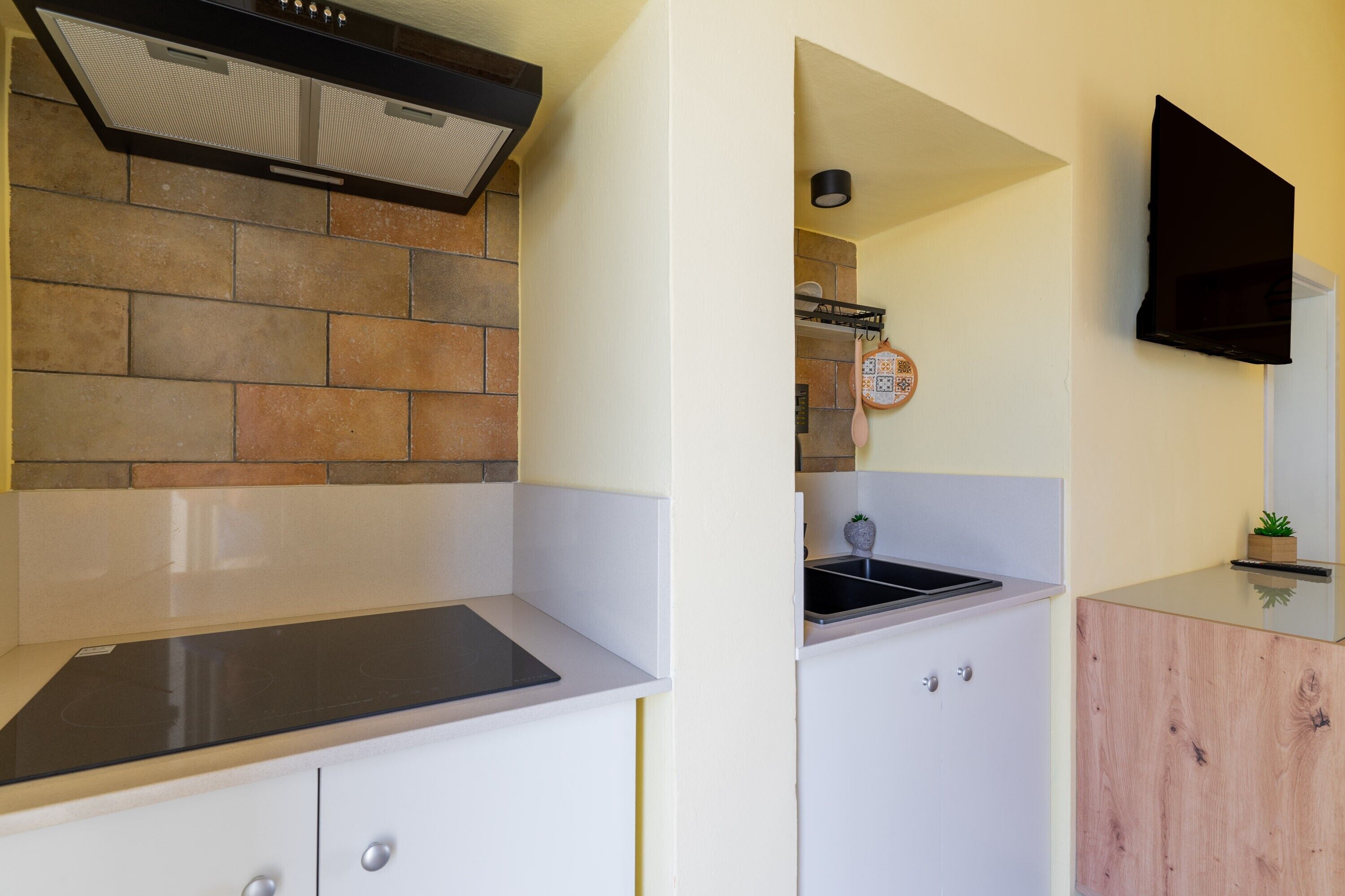 A compact kitchen with a stove, a microwave, and a sink.