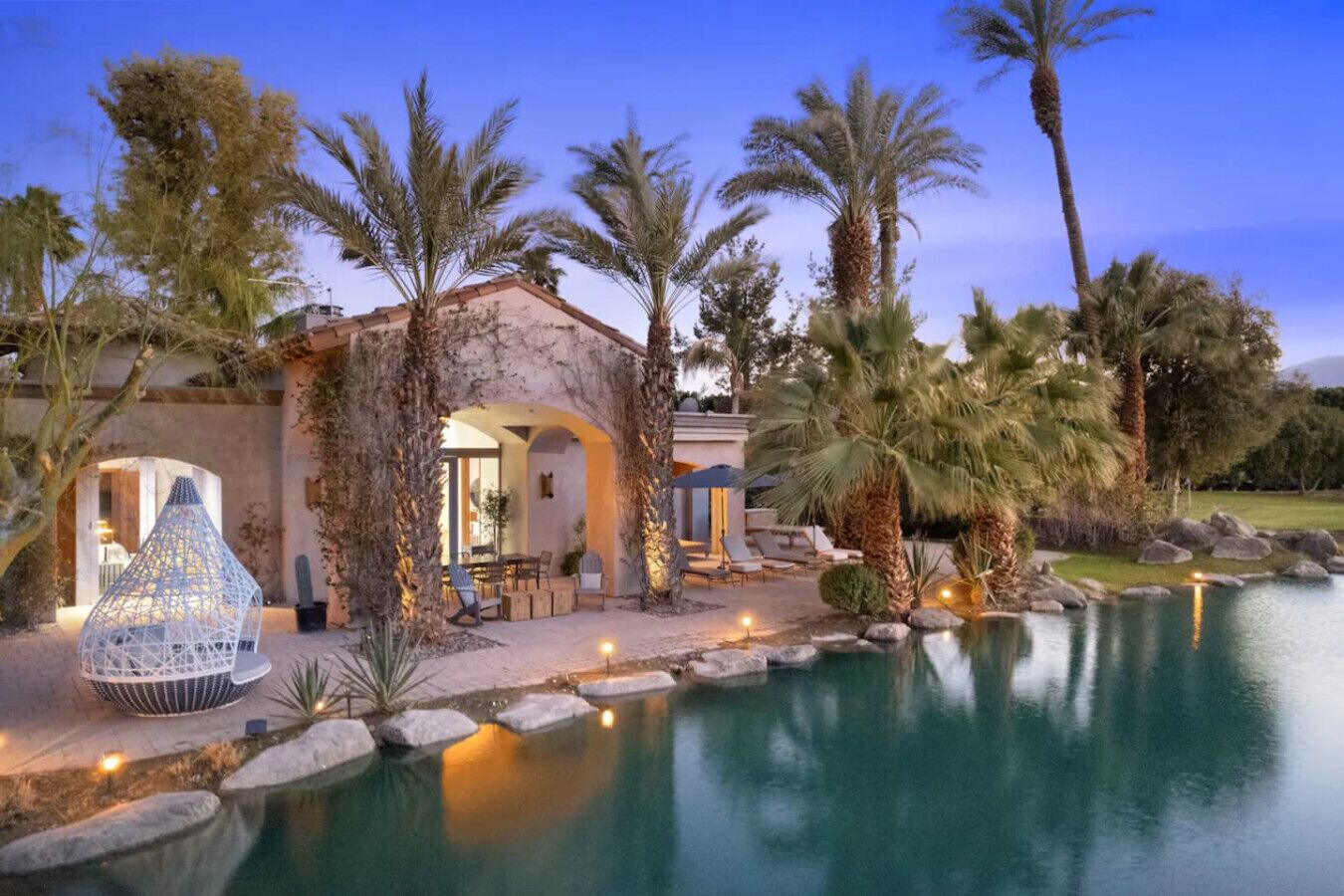A luxurious villa with a swimming pool, outdoor seating, and a well-maintained garden.