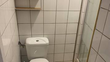 Een douche, handdoeken, zeep, toiletpapier