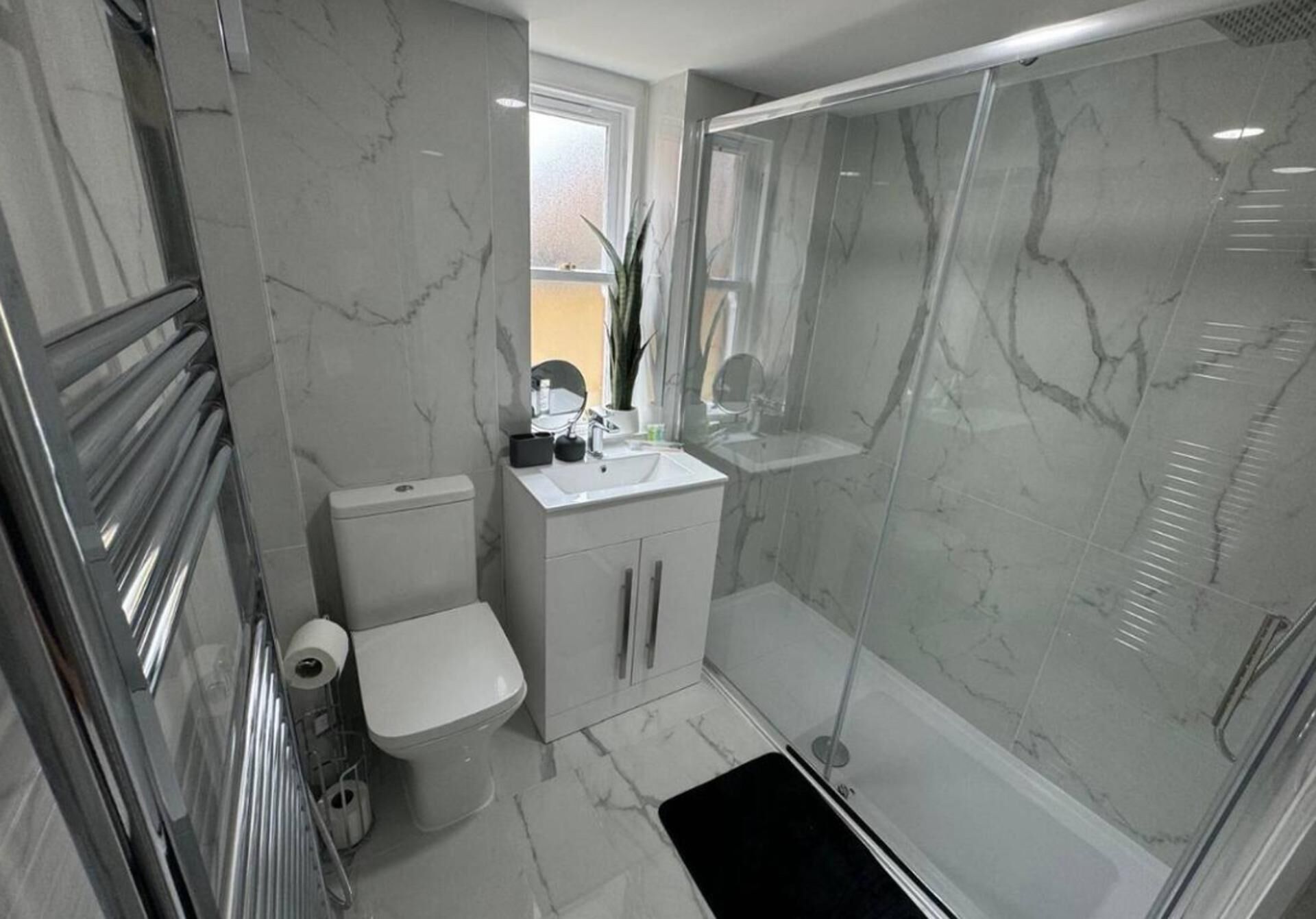 Une salle de bain moderne équipée de toilettes, d’un lavabo et d’une douche.