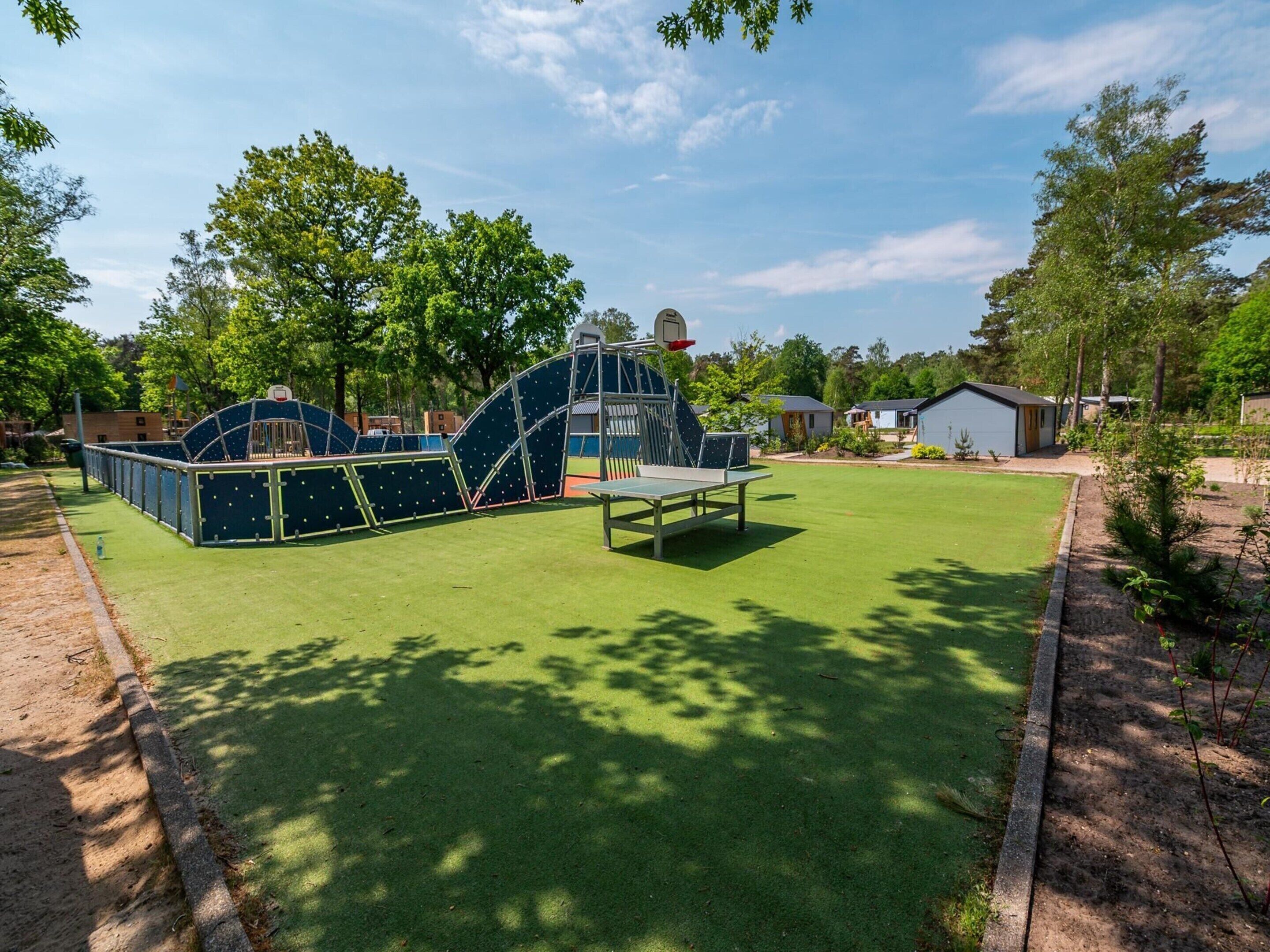 A playground with a climbing structure and a basketball hoop.