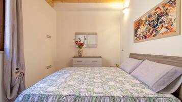 1 dormitori, planxa i posts de planxar i roba de llit