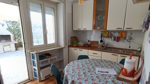 A kitchen with a dining table, chairs, and a window. - House by the sea with large equipped garden (Torvaianica)