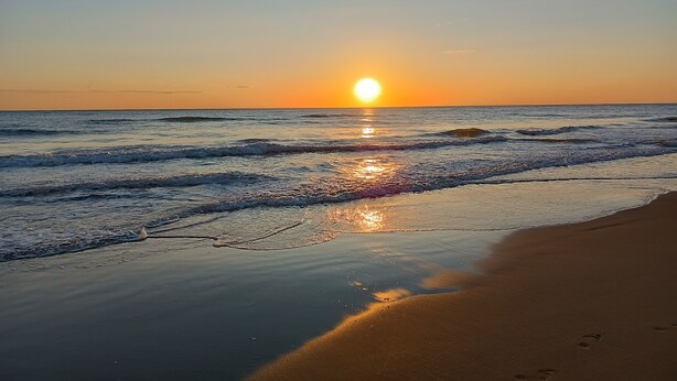A beach with a sunset, waves, and footprints on the sand. - House by the sea with large equipped garden (Torvaianica)