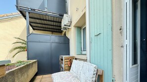 A small outdoor area with a mattress on a wooden pallet, a grey gate, and a blue door. - Les Capucines - Tournon-sur-Rhône (Tournon-sur-Rhône)