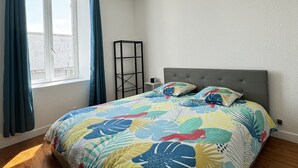 A bedroom with a bed, a window, curtains, a bedside table, and a hanging light fixture. - Les Capucines - Tournon-sur-Rhône (Tournon-sur-Rhône)