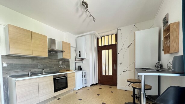 A modern kitchen with wooden cabinets, a built-in oven, and a coffee machine. - Les Capucines - Tournon-sur-Rhône (Tournon-sur-Rhône)