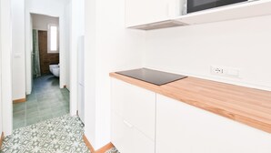 A kitchen with white cabinets, a microwave, and a wooden countertop.