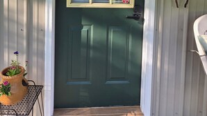 A green door with a window, a security system sign, and a metal mailbox. - Escape to Nature – 2 Bdrm Home on 13 Private Acres near ATV, SSRT trails and PSU (Munson)