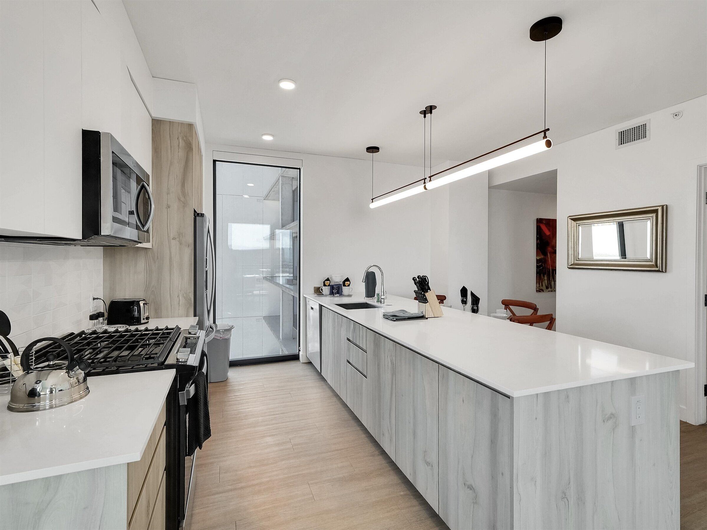 A modern kitchen with a central island, stainless steel appliances, and a minimalist design.