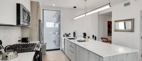 A modern kitchen with a central island, stainless steel appliances, and a minimalist design.