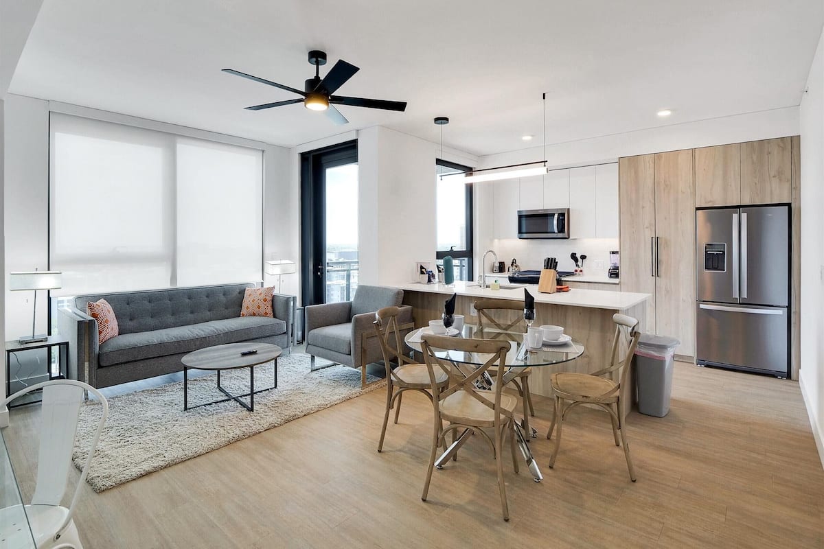A modern apartment with a living room, dining area, and kitchen.