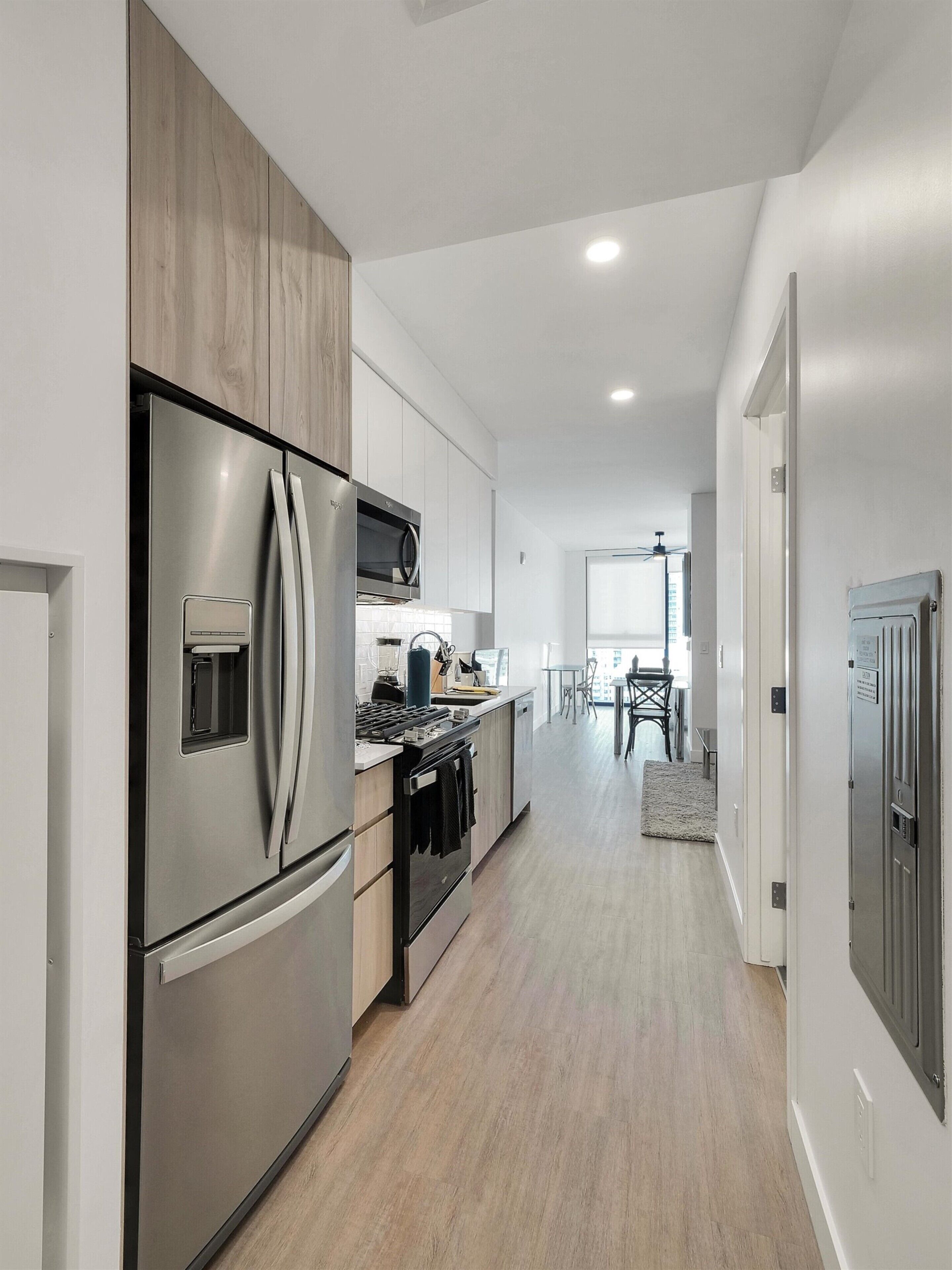 A modern kitchen with stainless steel appliances, wooden cabinets, and a central island.