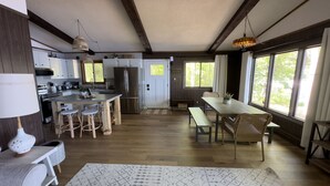 A spacious kitchen with modern appliances, a dining area with wooden furniture, and large windows offering natural light. - Lakefront Stay w/ATV Trail Access -Trailer Parking (Iron River)