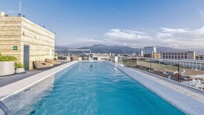 Piscina no terraço com vista desobstruída para montanhas ao fundo.