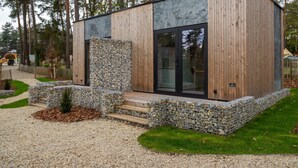 A modern cabin with a stone facade, wooden exterior, and large glass doors. - Nice Studio With Kitchenette 16 km From Maastricht (Zutendaal)