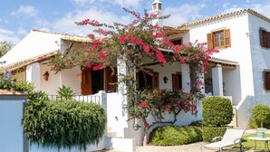 A white villa with a swimming pool, a covered patio, and a garden with flowering plants. - Almancil Sea and Countryside Secluded Villa (Loulé)