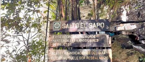 A wooden sign with multiple instructions for hikers at Salto del Sapó.