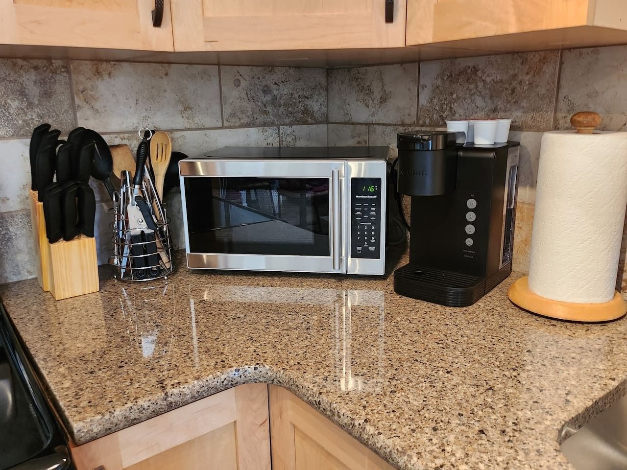 Une cuisine équipée d’un four à micro-ondes, d’une machine à café et d’un porte-rouleau d’essuie-tout.