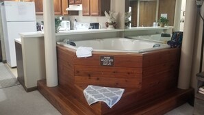 Un baño con una bañera de madera, una toalla y un letrero de precaución.