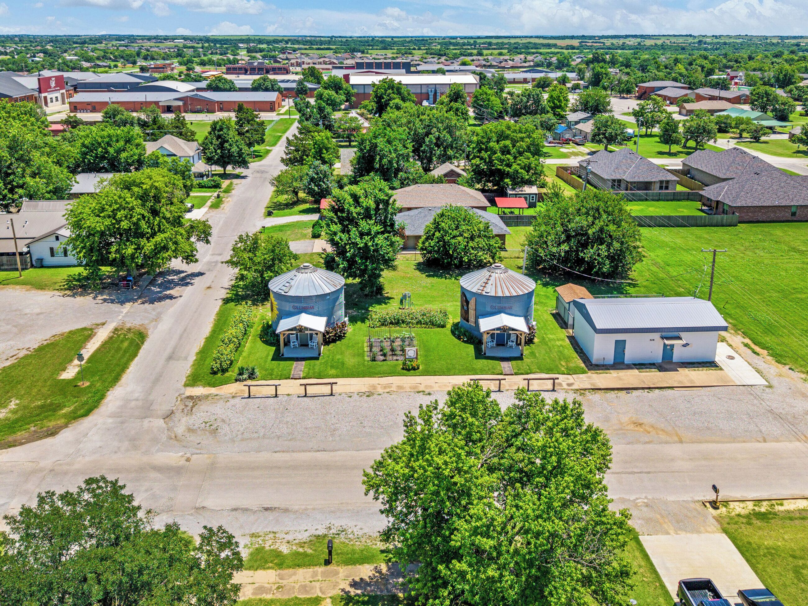 An aerial view of a residential area with two cylindrical water tanks labeled "Columbus" and a small building with a blue roof.