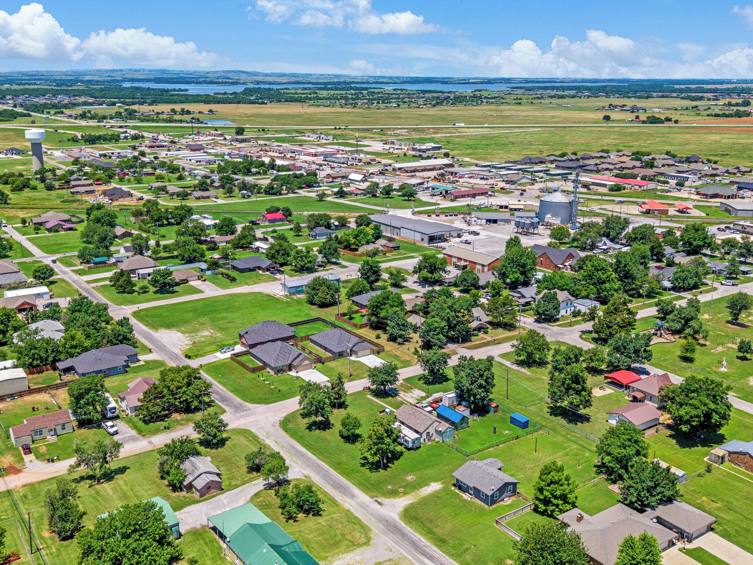 Vista aérea de un pueblo con zonas residenciales, edificios industriales y una gran torre de agua.