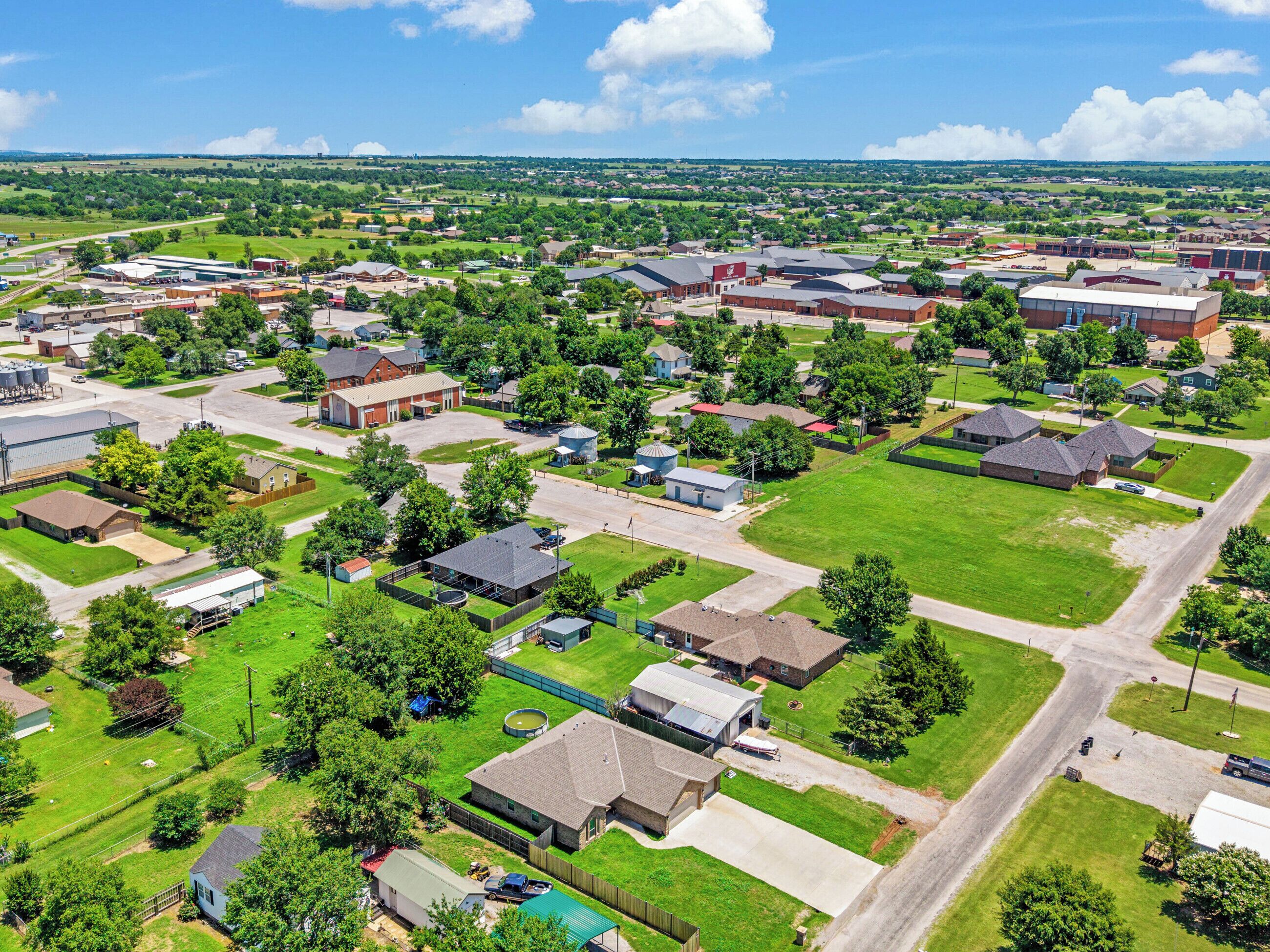 An aerial view of a residential area with houses, roads, and green spaces.