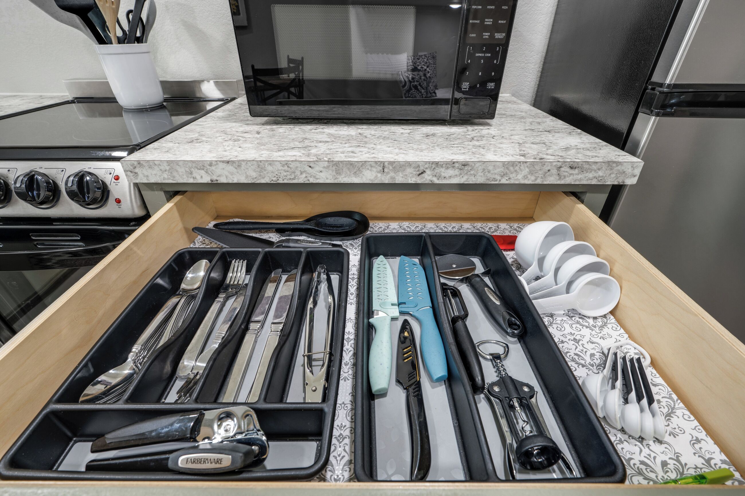 Un cajón de cocina con utensilios y utensilios de cocina ordenados.