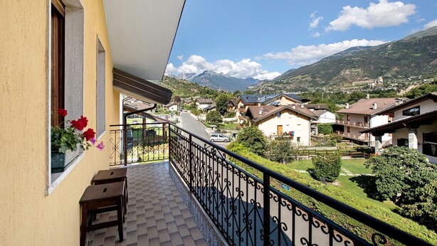 A balcony with a view of a residential area, a mountain, and a church. - Apartment 'Casa Lella Clemy' with Mountain View, Balcony and Wi-Fi (Aymavilles)
