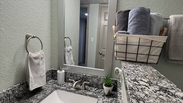 Secador de cabelo, toalhas de banho, sabonete, shampoo