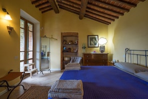 Un dormitorio con una cama grande, un aparador, un espejo y una silla.