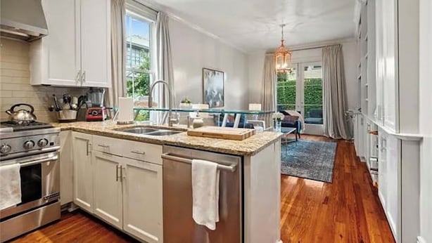 Una cocina moderna con armarios blancos, electrodomésticos de acero inoxidable y una isla grande.