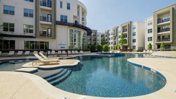 A modern apartment building with a swimming pool area, including lounge chairs and a pool with a 3ft 6in depth marker. - POOL VIEW/DOWNTOWN DALLAS/MEDICAL DISTRICT/DALLAS LOVE FIELD (Dallas)