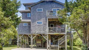A multi-story wooden building with a balcony and a covered porch area. - Oceanside, Ocean Views, Sound Views, Sundeck, Short Walk To The Beach! (Hatteras)