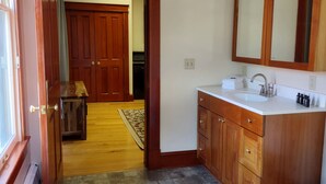 A bathroom with wooden cabinets, a white sink, and a mirror.