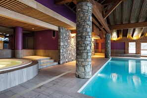 An indoor swimming pool with stone pillars, a hot tub, and a wooden ceiling. - Navette gratuite pour la station + Accès Piscine (Pralognan-La-Vanoise)