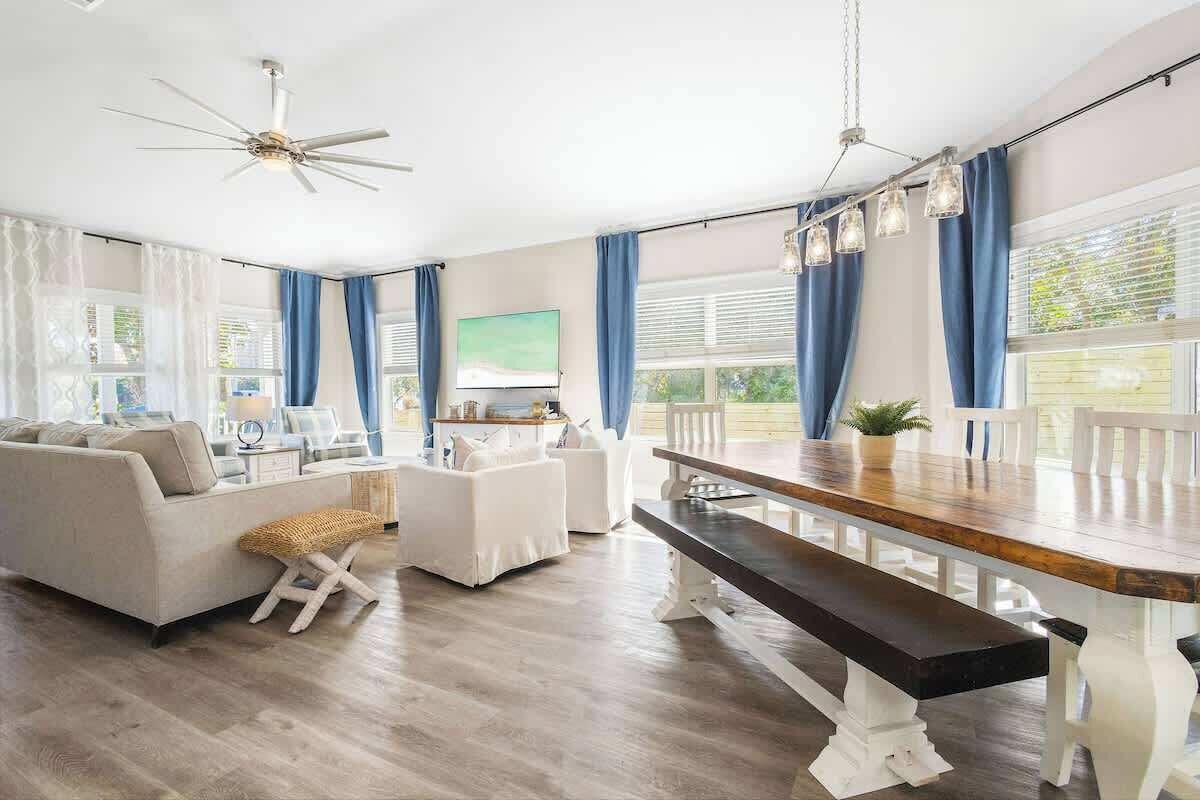A spacious living area with a sofa, ottoman, dining table, and bench.