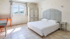 A bedroom with a bed, a desk, and a wardrobe. - Charmant T4 climatisé | Accès aux piscines (Callian)