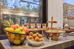 Un buffet de petit-déjeuner comprenant des fruits, des viennoiseries et diverses garnitures.